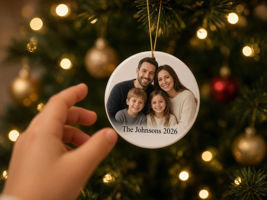 Round ceramic family photo ornament on a lit Christmas tree