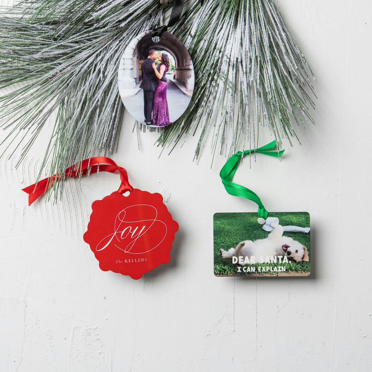 Metal photo ornaments hanging on a Christmas tree branch