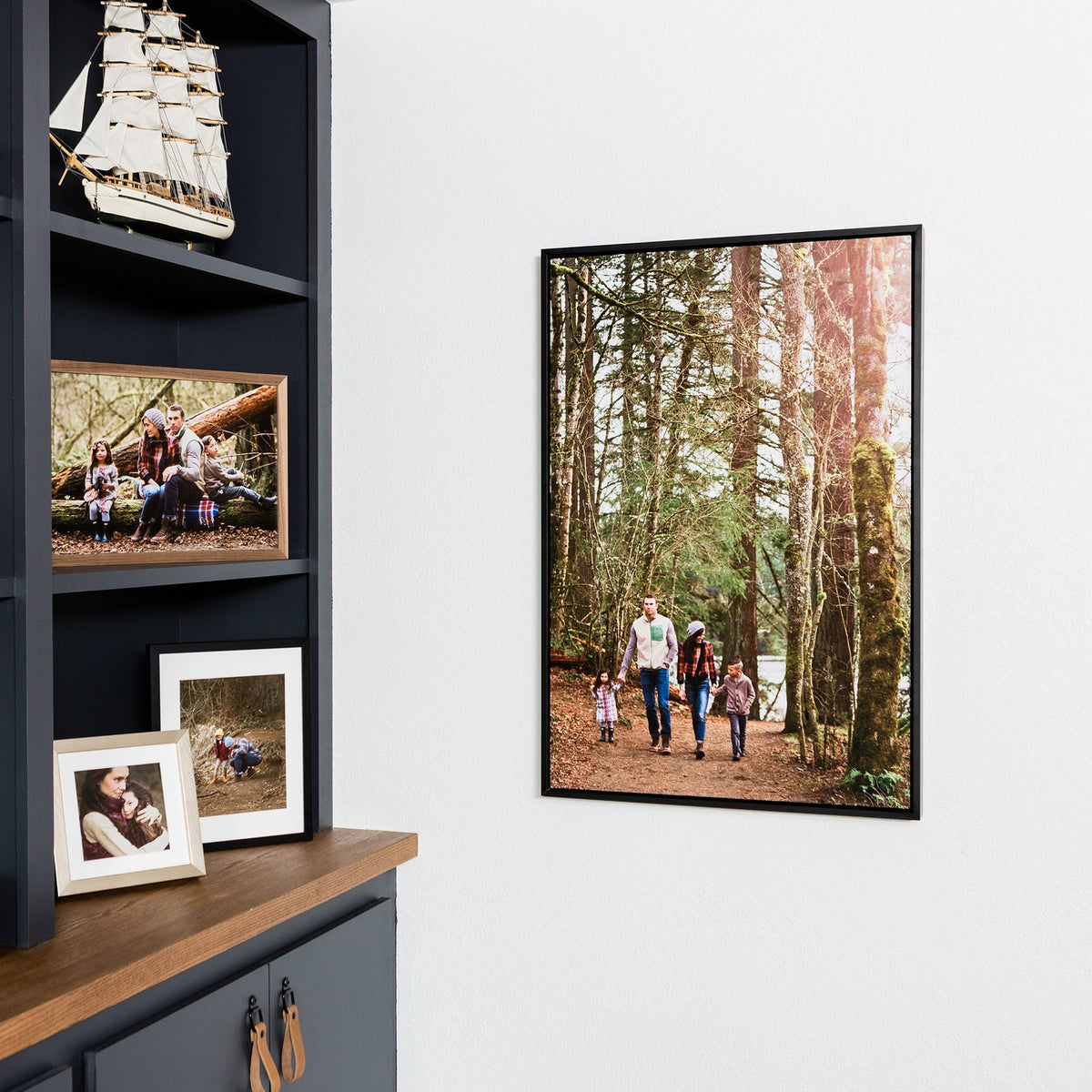 Metal print in a thin black inset frame of a family walking in the woods